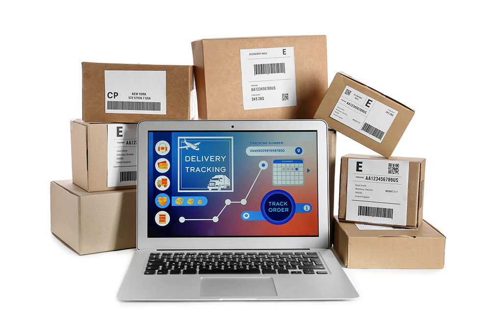 Laptop with open page of delivery service application and parcels on white background