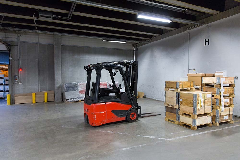 logistic, storage, loading, shipment and equipment concept - forklift loader and boxes at warehouse